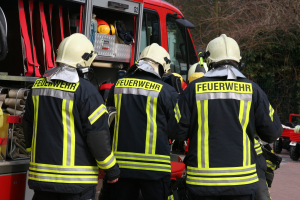 Feuerwehrmänner vor einem Feuerwehrwagen