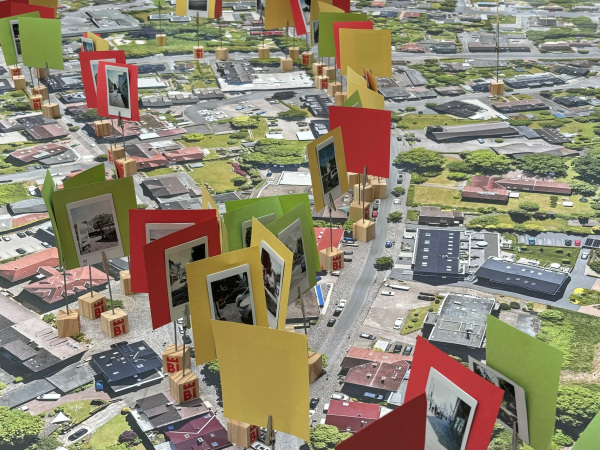 Es ist der Stadtplan von Heepen zu sehen. An den unterschiedlichen Orten stehen Memohalter mit Fotos und jeweils roten, gelben und grünen Fähnchen.
