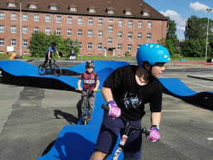 Jugendliche und Kinder fahren mit Rädern und Roller über den Pumptrack auf dem Gelände der Rochdale Barracks. Foto: Stadt Bielefeld